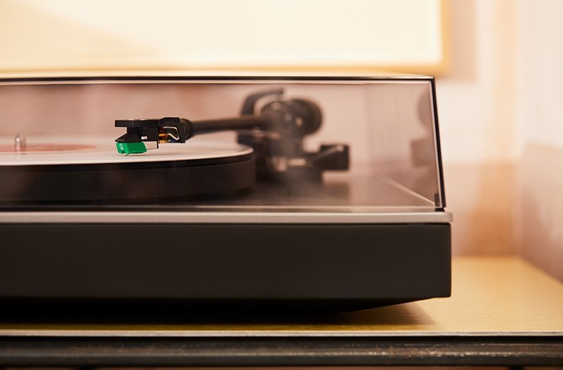 close-up of alva st turntable with dust cover down focusing on tonearm and cartridge
