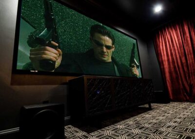 Stewart Filmscreen hanging on wall of home theater with scene from The Matrix